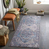 Entryway scene with a blue Neyland Iris Blue Area Rug, bench, mirror, plants, and decor. Roomscene-Runner