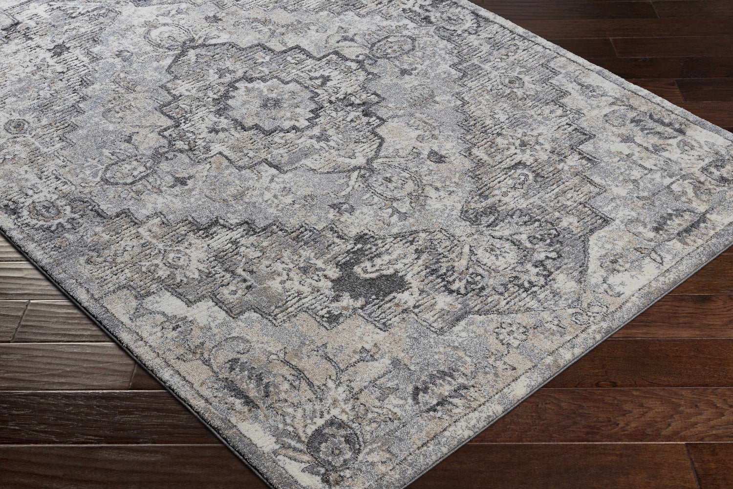 Close up of the Hagdan Thick Luxe Rug in cream, gray, and beige on a dark wood floor. Oriental style pattern. Corner