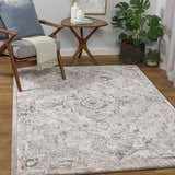 Living room scene with a cream and gray Hagdan Thick Luxe Rug, wood floors, chair, side table, and plant. Roomscene-Rectangle
