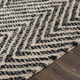 Close-up of the Halton Area Carpet showing its cream and charcoal hand-woven, textured geometric design. Texture