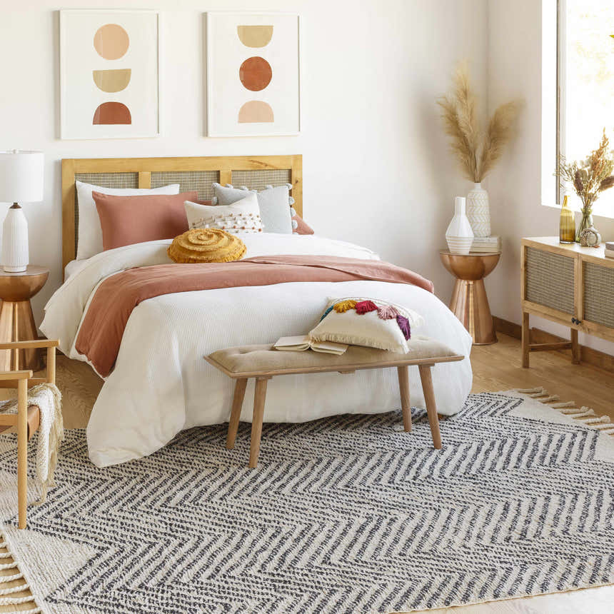 Bedroom scene with a charcoal and cream Halton Area Carpet, wood furniture, and neutral decor. Roomscene-Rectangle