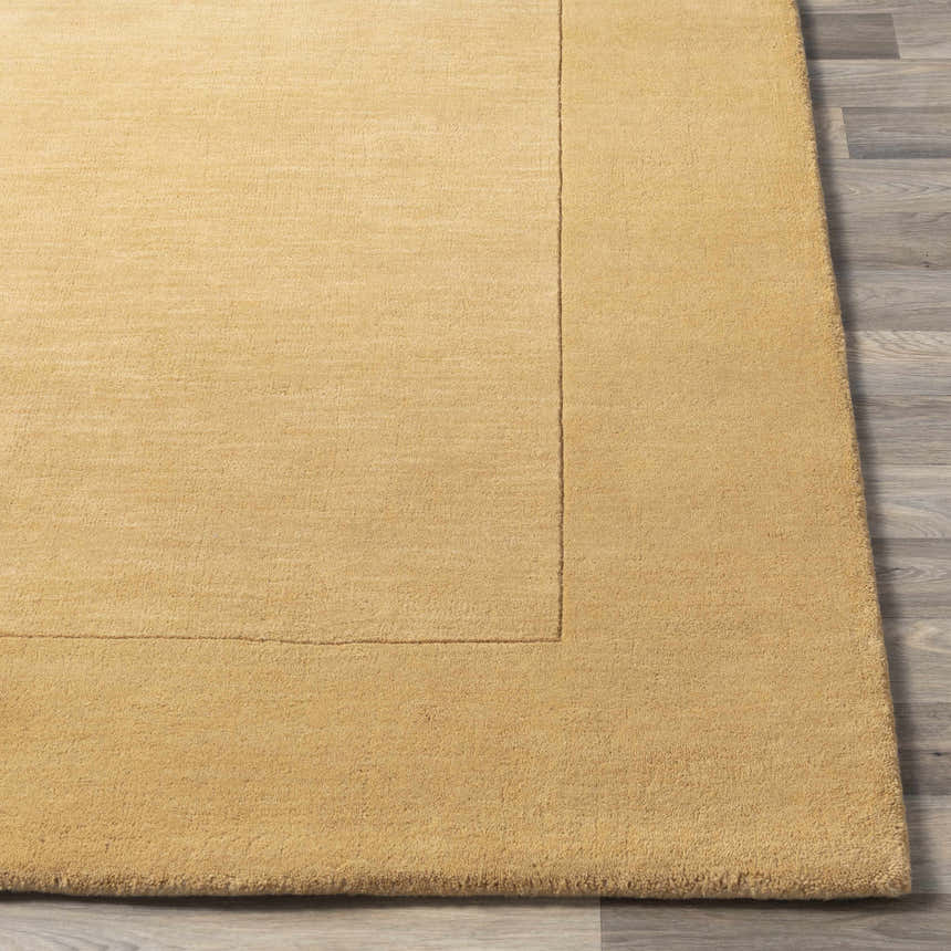 Close up of a Bordered Solid Camel Yellow Wool Rug showing texture and border detail. Front