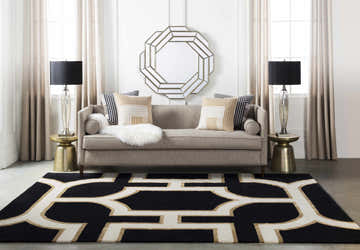 Living room scene with Hamtramck Hand Tufted Wool Area Rug in black, ivory, and brown under a sofa with accent pillows. Roomscene-Rectangle