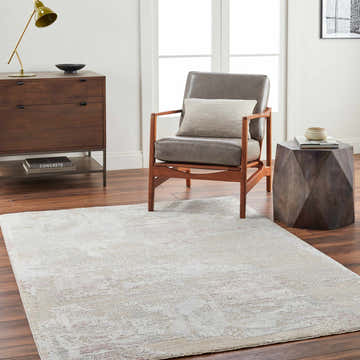 Living room scene with a beige Hanae Thick Luxe Boutique Rug, gray chair, and wood furniture. Roomscene-Rectangle
