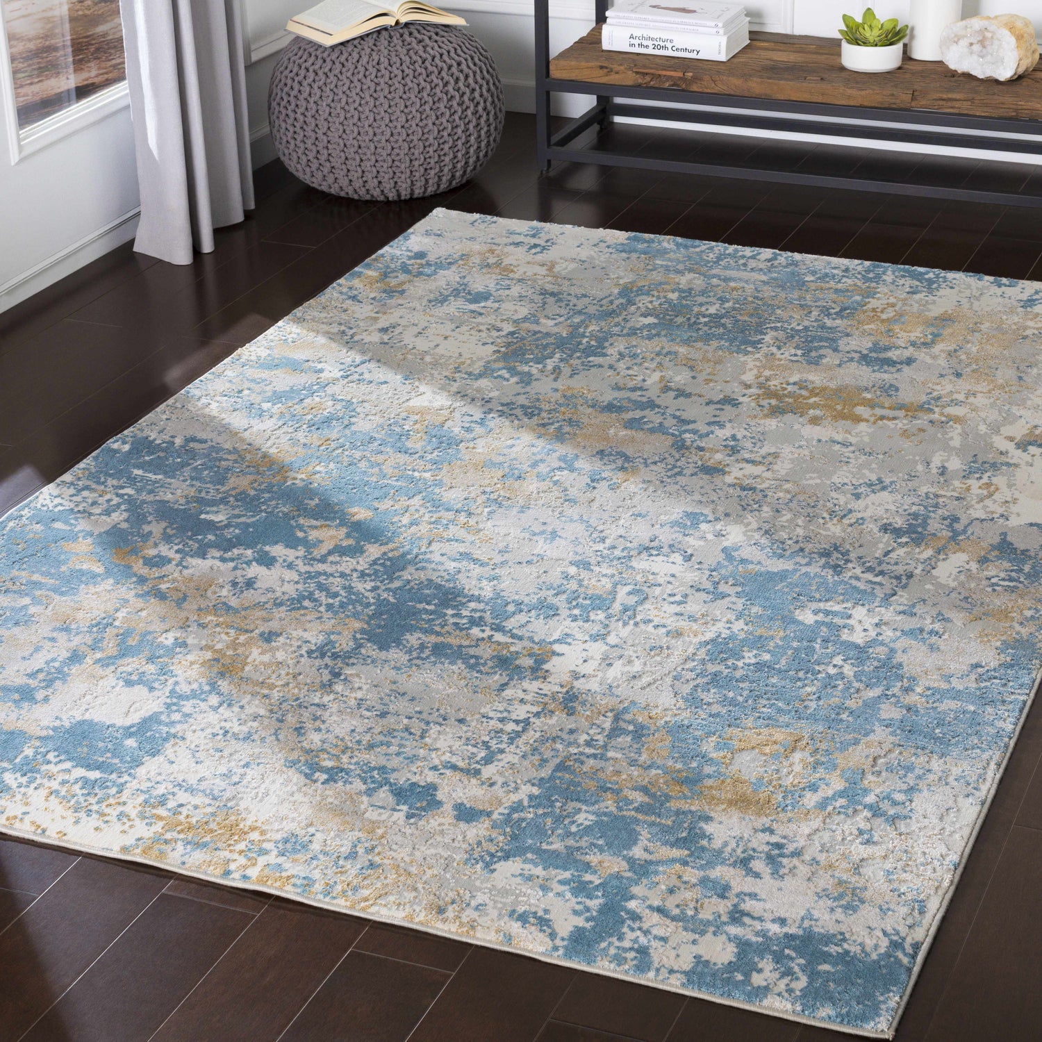 Living room scene with a Hawes Faux Silk Rug in light blue, gray, and mustard on dark wood floors. Contemporary style. Roomscene-Rectangle