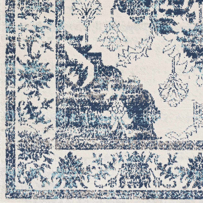 Close-up of the Helidon Area Rug. Features a traditional floral pattern in gray, light blue, and navy on a light beige background. Swatch
