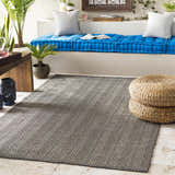 Relaxed sunroom with blue cushions and a Herlong Charcoal Herringbone Rug. Roomscene-Rectangle