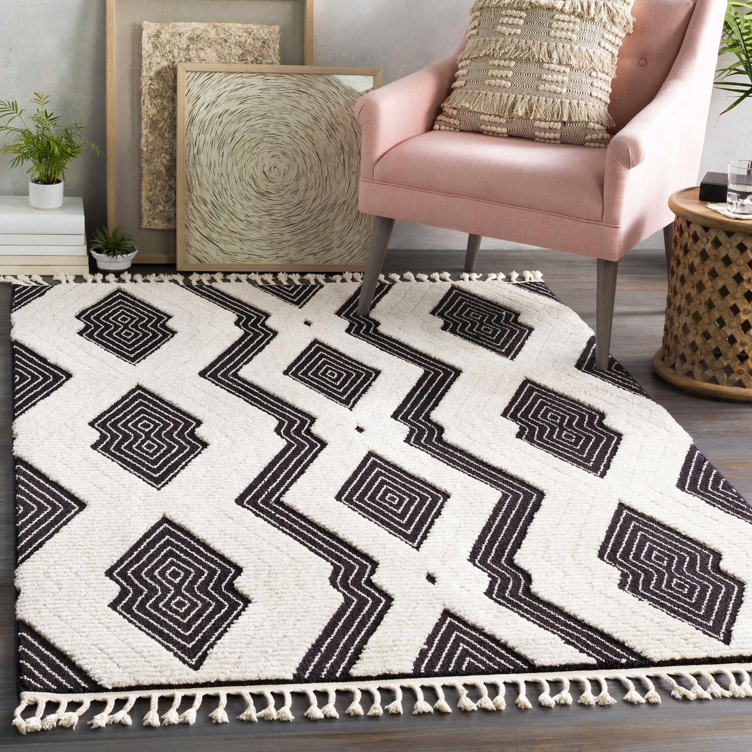 Living room scene with black and ivory Hesperus High/Low Pile Rug, pink chair, and geometric art. Bohemian style. Roomscene-Rectangle