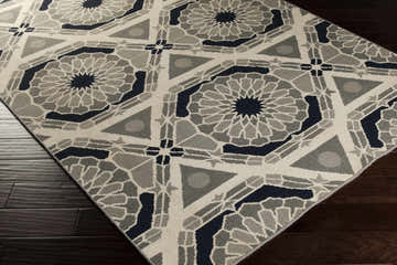 Close-up of the hand-knotted Hetland Area Carpet. Beige, charcoal, gray, and navy geometric pattern on 100% wool. Corner