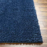 Close-up of the plush texture and dark blue color of the Faina Solid Shag Washable Area Rug. Front