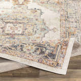 Close-up of the Hillcrest Area Rug. Beige, blue, red, and yellow tones in a traditional, distressed oriental pattern. Soft texture. Fold
