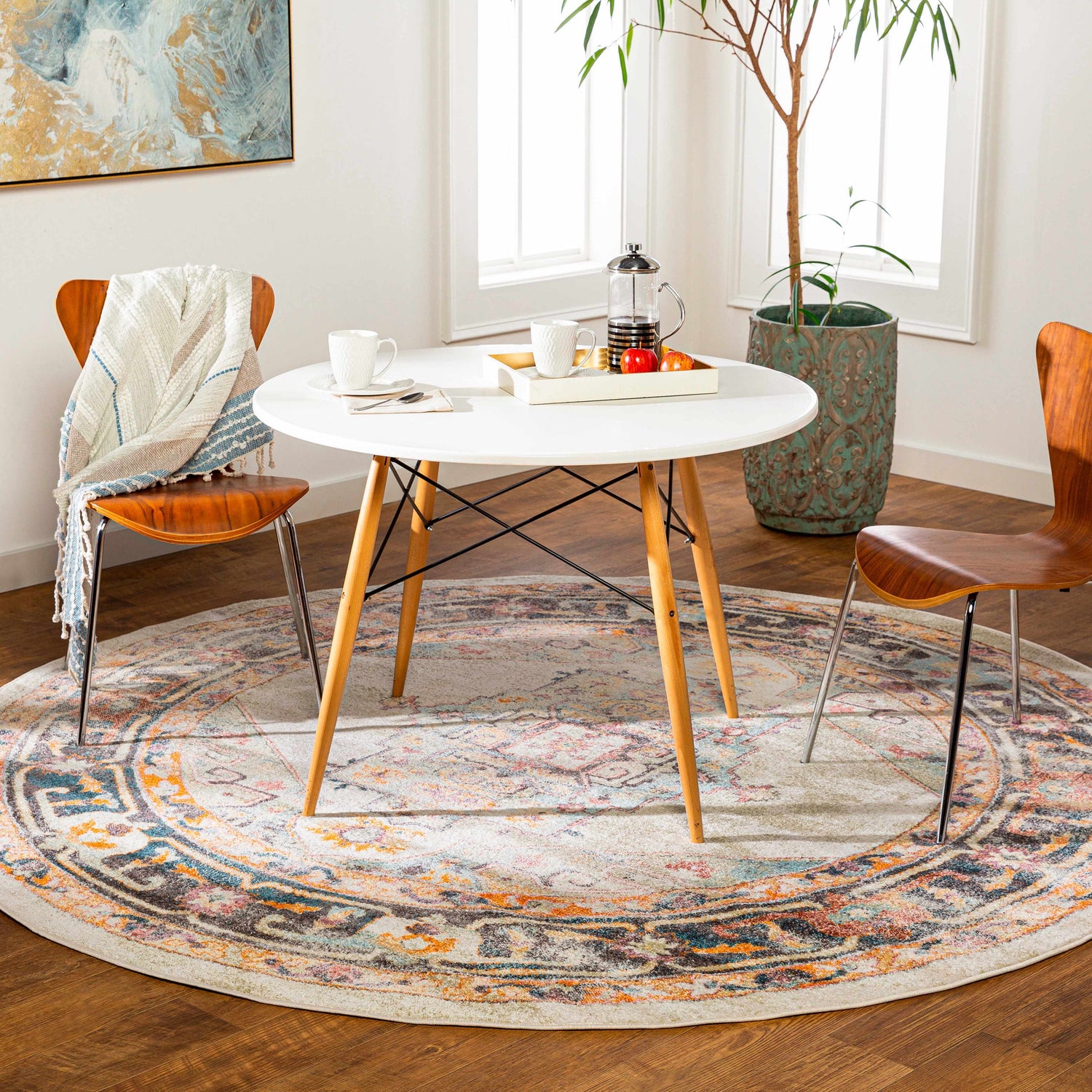 Bright breakfast nook with a round Hillcrest Area Rug in beige, blue, and orange tones. Roomscene-Round