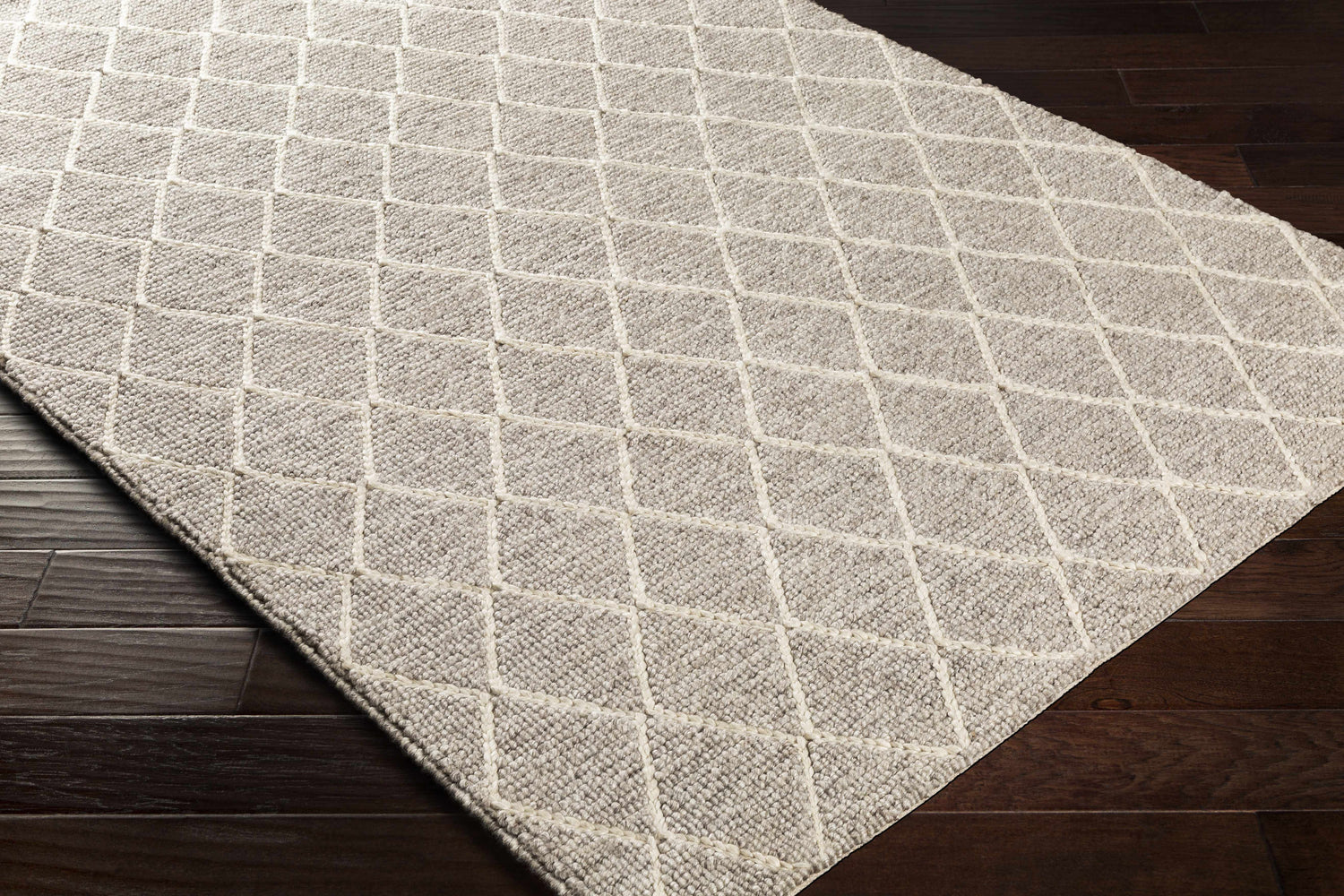 Close up of hand woven Hindley Area Rug in cream and gray with a geometric diamond pattern. Corner