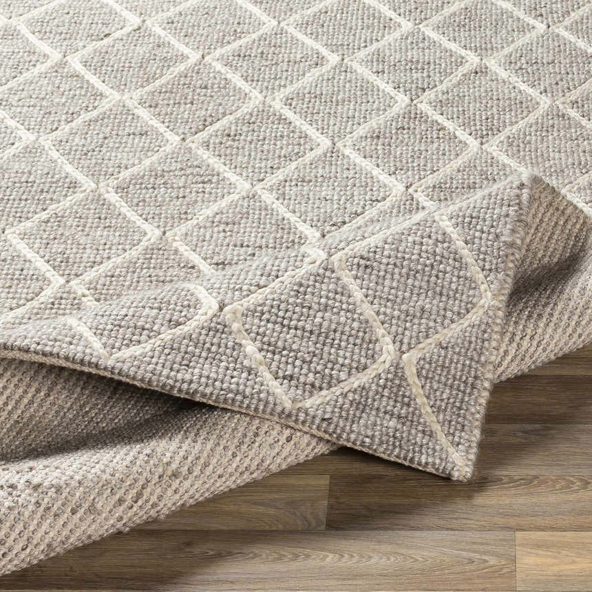 Close-up of the hand woven Hindley Area Rug. Cream and gray wool rug with a contemporary diamond pattern. Fold