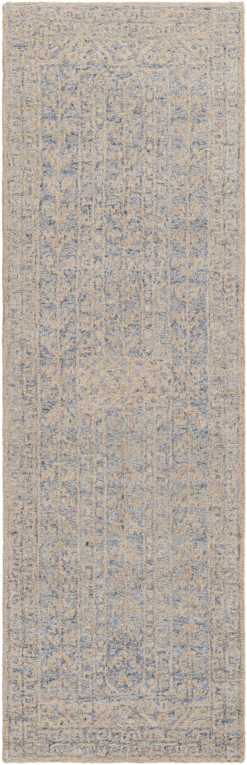 Close up of the hand-tufted Hinton Wool Area Rug, featuring a beige and blue bohemian pattern. Design-Runner-268