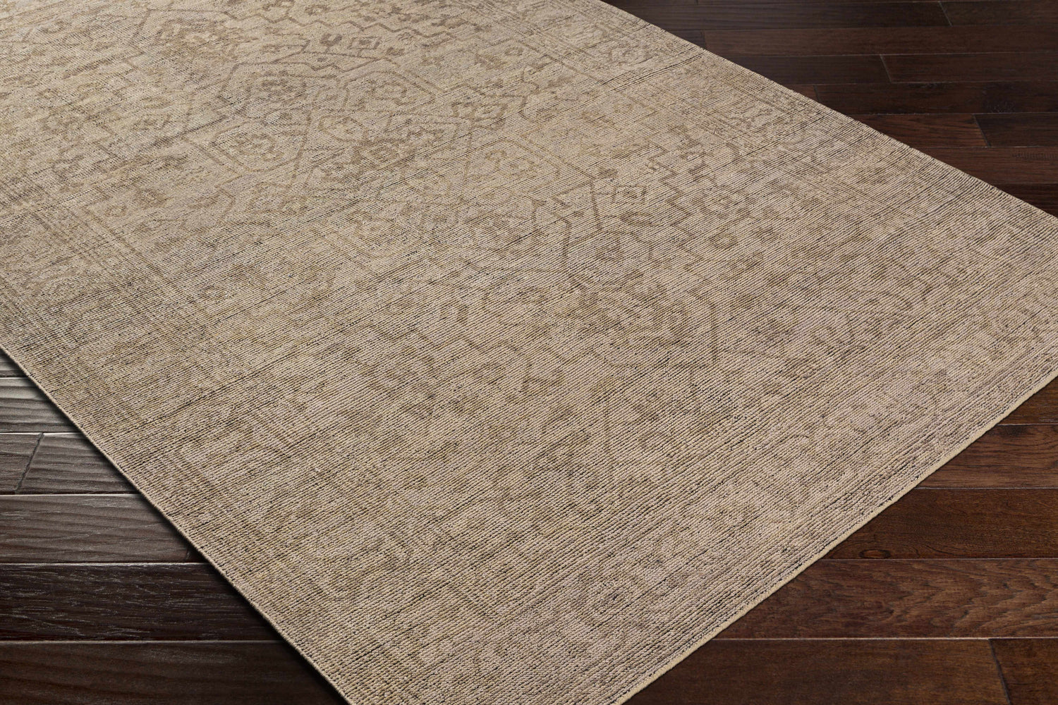 Close-up of a beige Hollym Premium Rug showing its subtle traditional pattern and hand-knotted wool texture. Corner