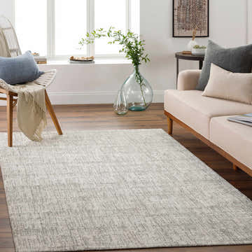 Living room scene with a charcoal and cream Hollywell Luxe Rug, beige sofa, and natural light. Roomscene-Rectangle