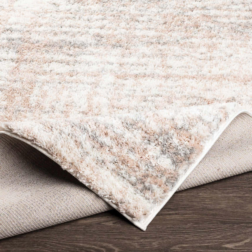 Close-up of the plush Hammond Dusty Pink Rug showing cream, gray, and pink tones and soft texture. Fold