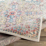 Close-up of the Hemingbrough Red&White Medallion Rug showing its red, blue, and saffron floral pattern and machine-woven texture. Fold