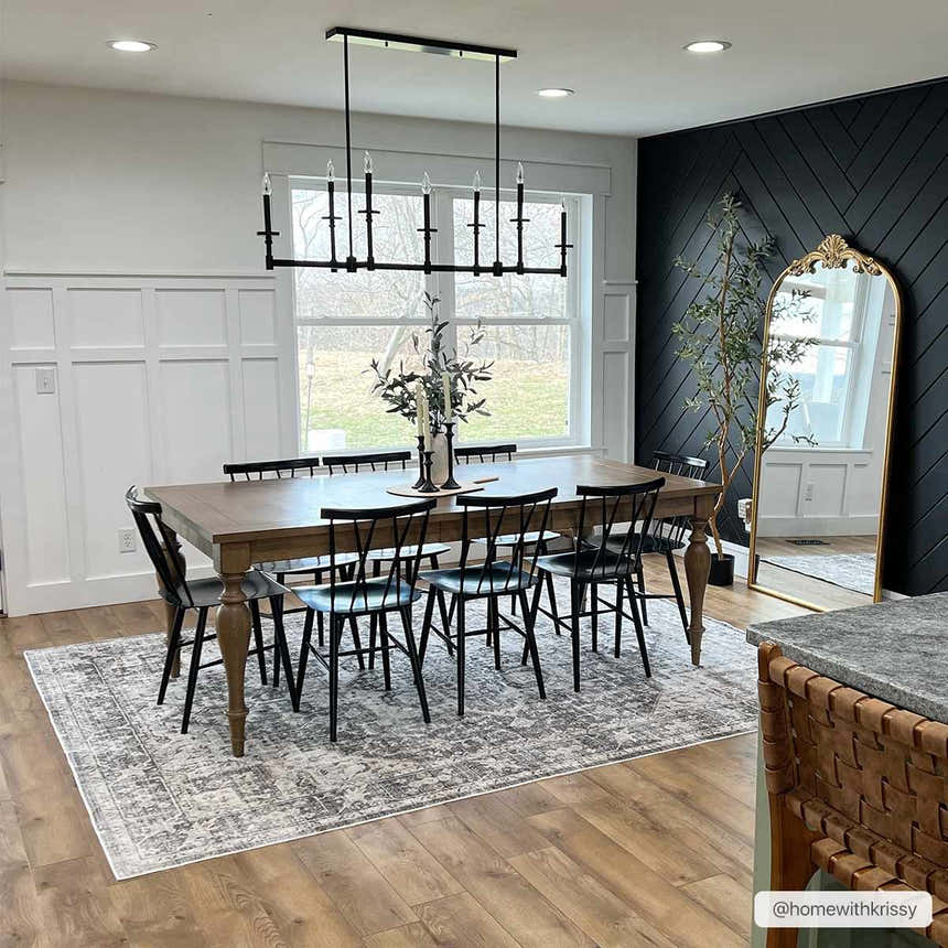 Farmhouse dining room with wood table, black chairs, and gray Bevin Washable Area Rug on wood floor. Black accent wall. Roomscene-Rectangle