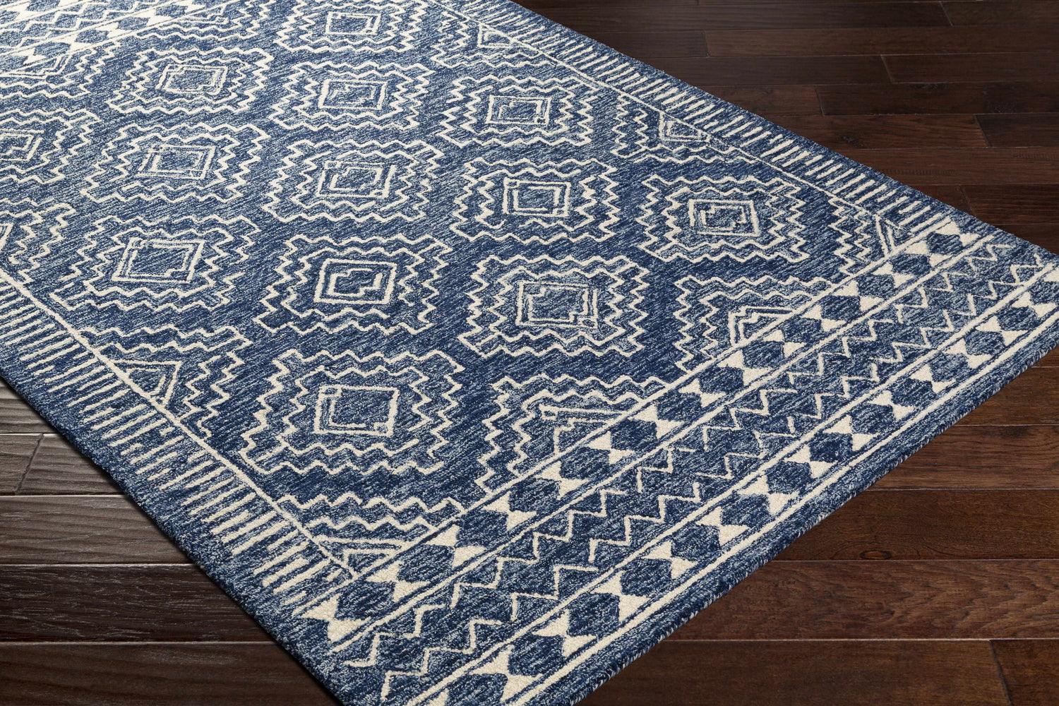 Close up of the Horton Modern Wool Rug in navy and beige with a geometric, bohemian pattern. Corner