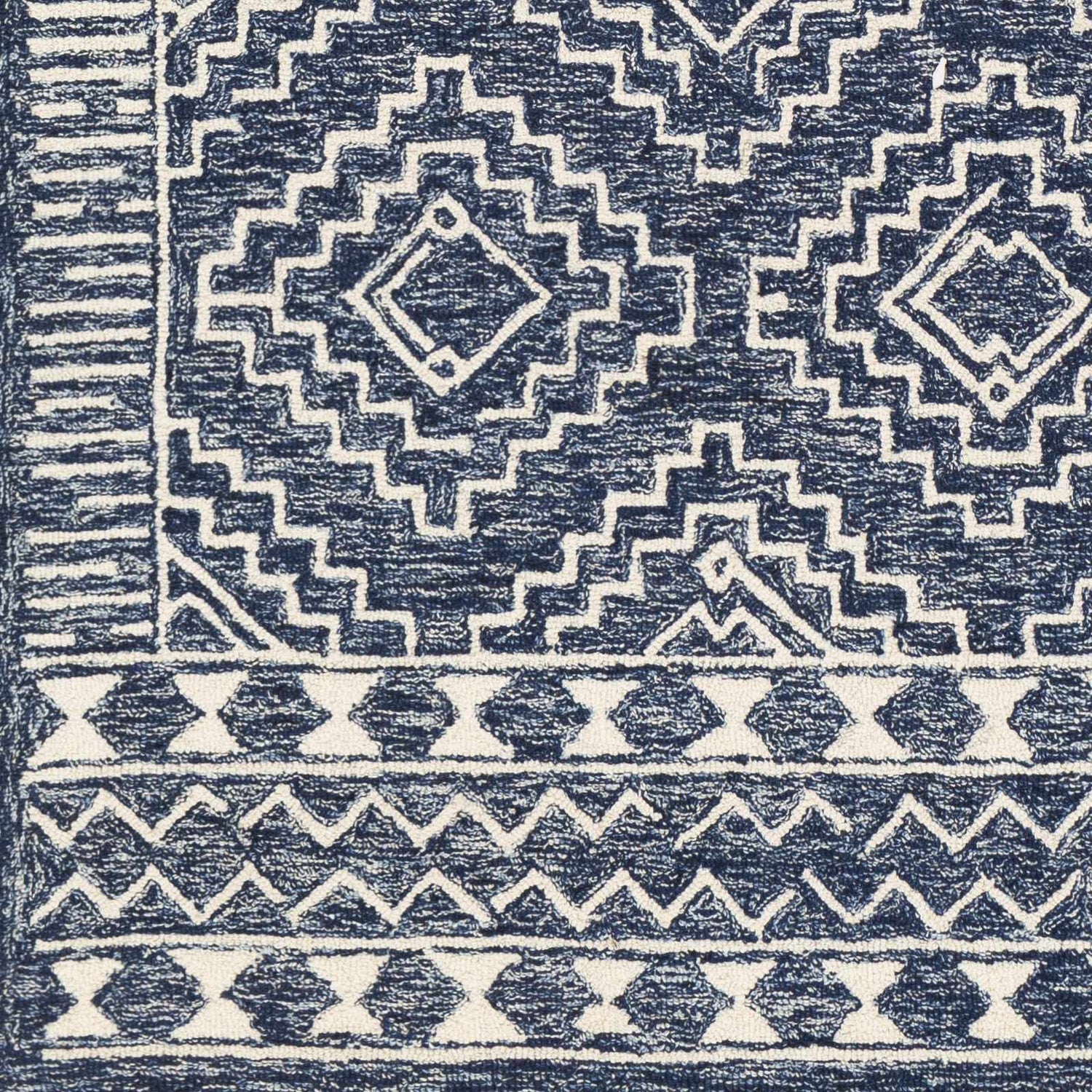 Close-up of the hand-tufted Horton Modern Wool Rug, featuring a geometric pattern in navy and beige. Swatch