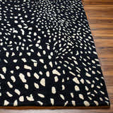 Close-up of the Athena Black Giraffe Print Wool Rug showing its black and beige animal-inspired pattern and hand-tufted texture. Front