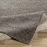 Close-up of the hand-knotted Hoyt Carpet, a contemporary rug in charcoal and off-white wool and viscose blend. Fold