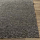 Close up of the charcoal and off-white Hoyt Carpet showing its hand-knotted texture and contemporary chevron pattern. Front