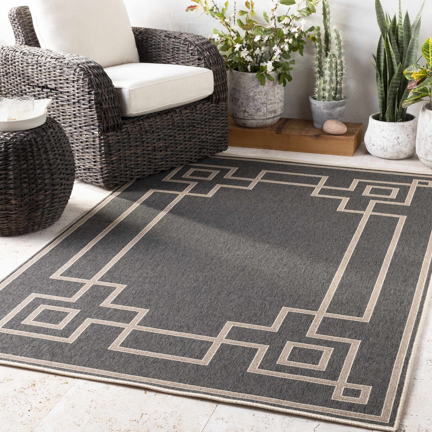 Outdoor patio scene with black wicker furniture and a Harborcreek Area Rug in black and light beige. Roomscene-Rectangle