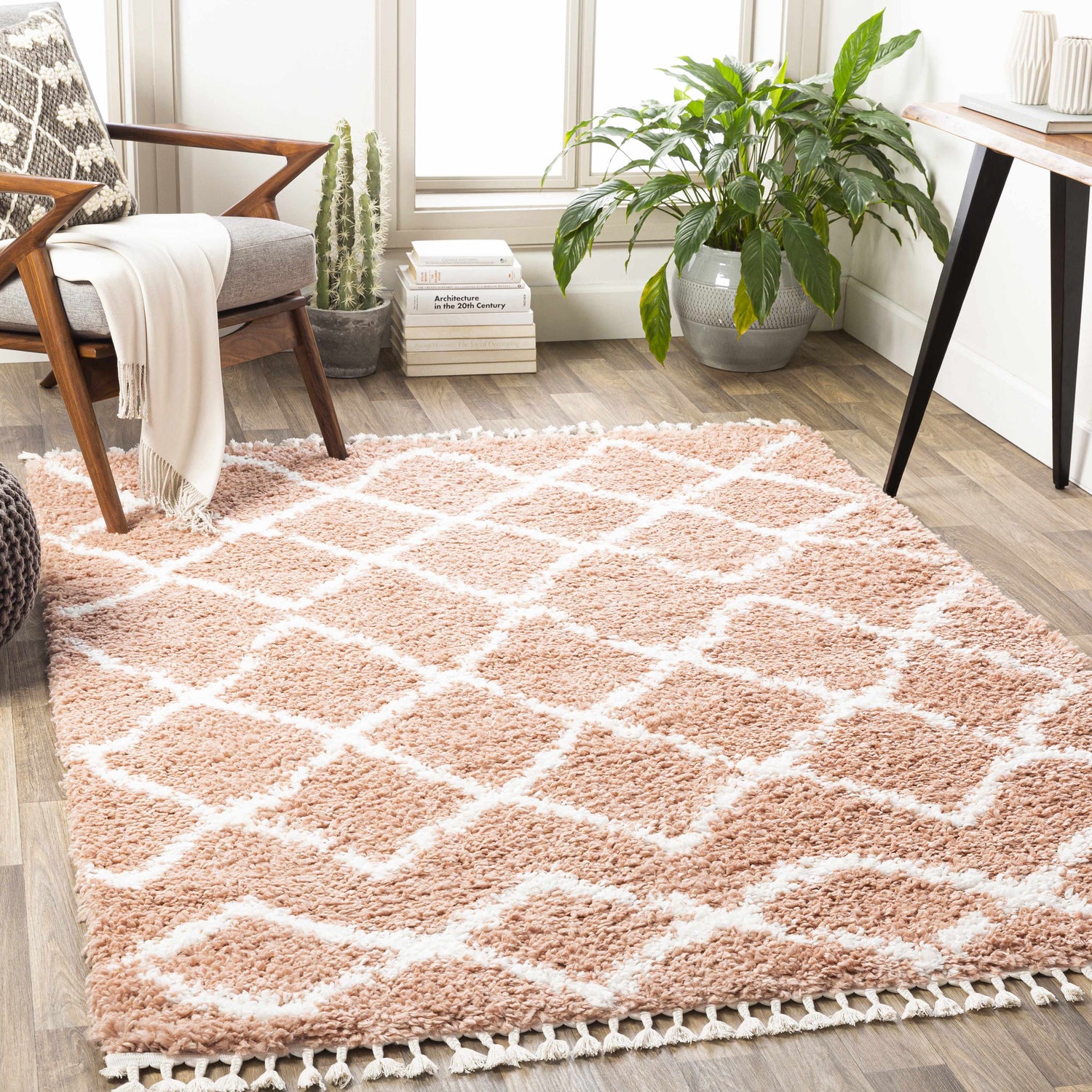 Living room scene with a dusty pink Hornsby area rug, white geometric pattern, chair, and plants. Roomscene-Rectangle