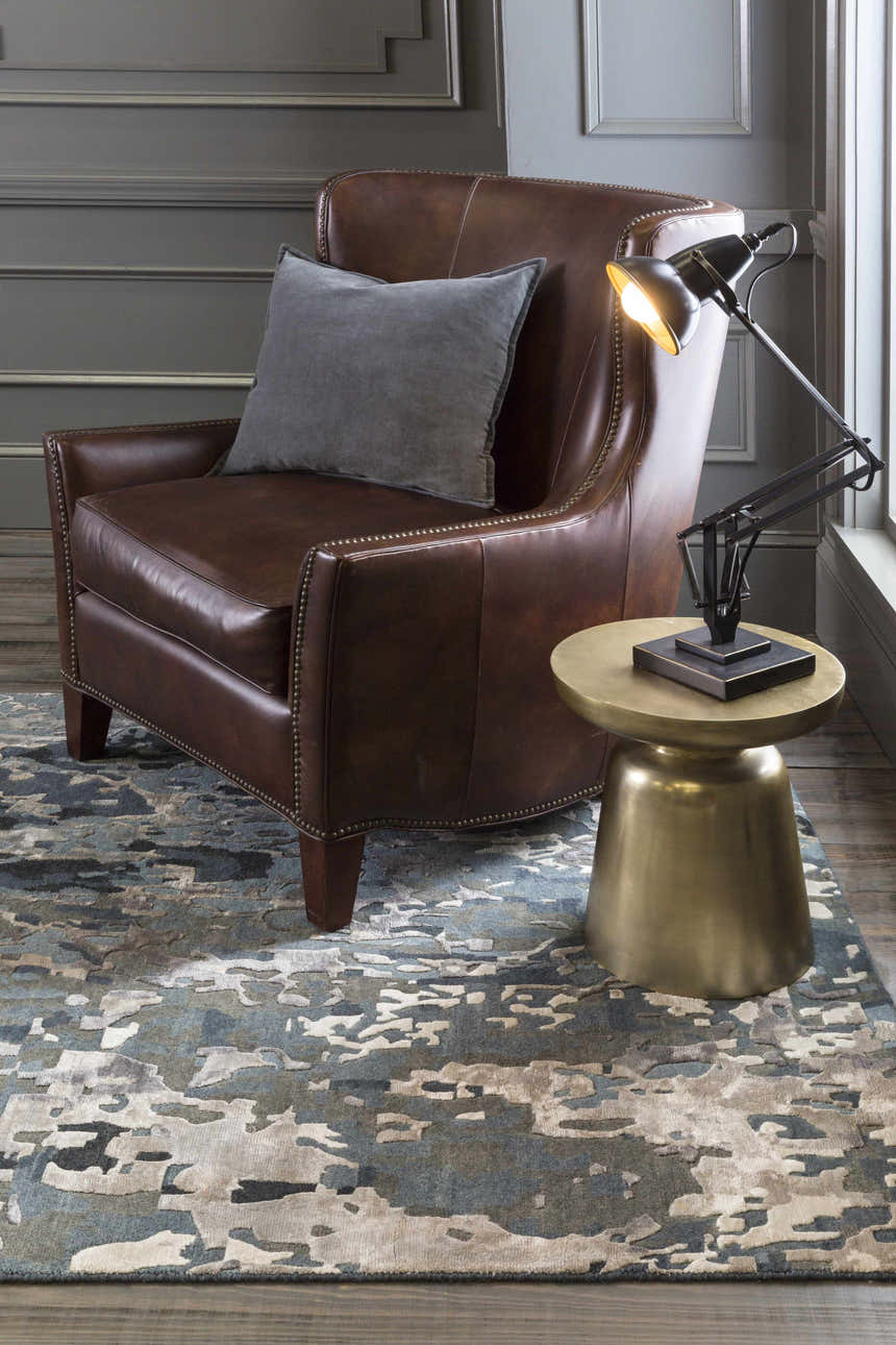 Living room scene with a brown leather chair on a blue and gray Ingomar Area Rug. Roomscene-Rectangle