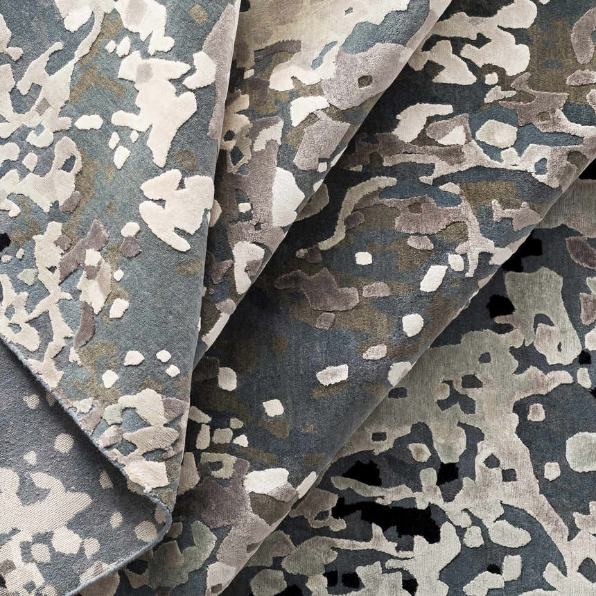Close-up of the Ingomar Area Rug showing its contemporary abstract pattern and viscose texture in denim, sage, and gray. Styleshot