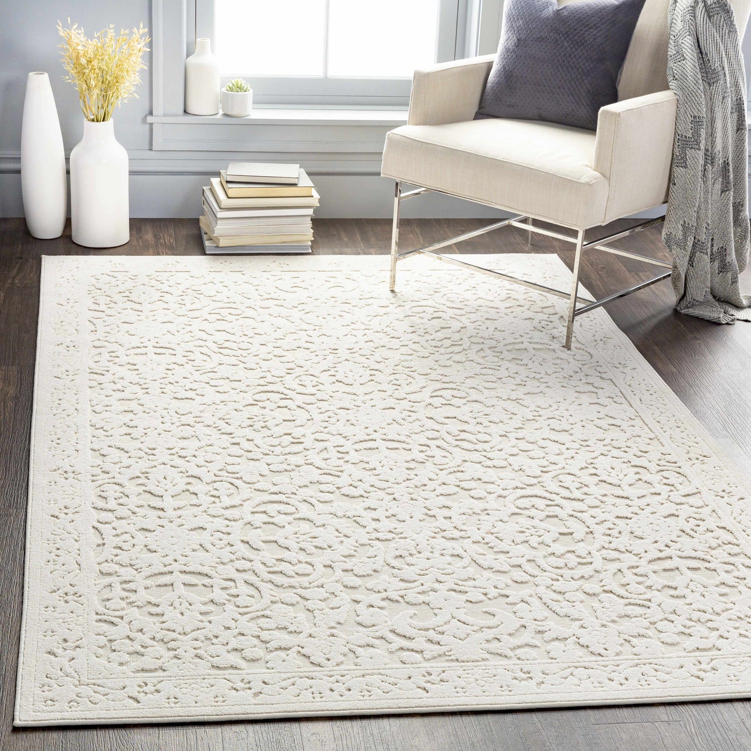 Living room scene with a beige Innaloo 3D Outdoor Area Rug, chair, throw blanket, and dark wood floors. Roomscene-Rectangle