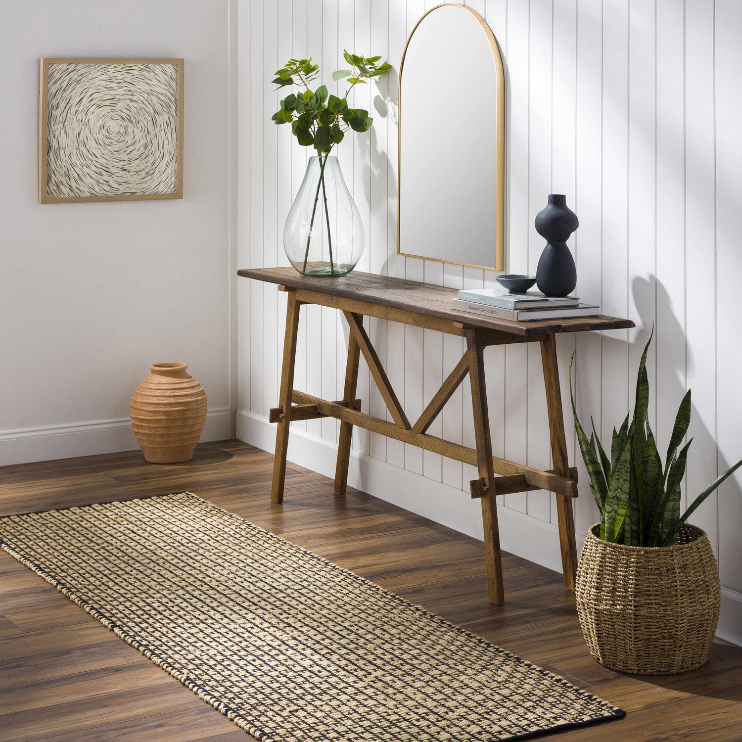 Entryway scene with Iqaluit Natural Jute Rug, wood console table, mirror, plants, and neutral decor. Roomscene-Runner