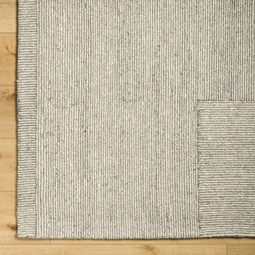 Close up of the hand tufted Isamu Area Rug. Dusty sage and medium gray wool rug with subtle stripe pattern. Corner