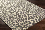 Close-up of the Iseul Leopard Print Area Rug showing its dark gray leopard spots on a taupe background. 100% Wool rug. Corner