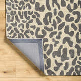 Close-up of the Iseul Leopard Print Area Rug. Hand-tufted wool rug with a dark gray and taupe animal print pattern. Fold