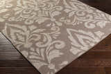 Close up of the taupe and light gray Ivybridge Area Carpet with a traditional floral pattern. Corner
