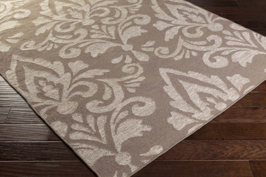 Close up of the taupe and light gray Ivybridge Area Carpet with a traditional floral pattern. Corner