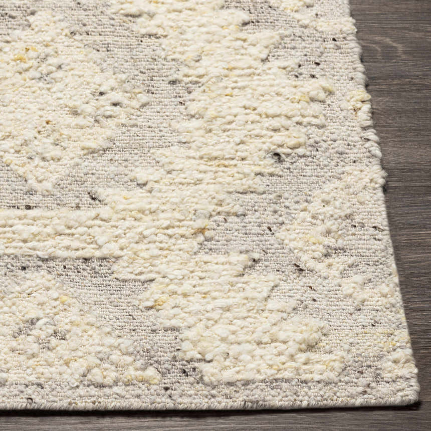 Close-up of the hand woven Jagupit Area Rug. Brown, cream, and light gray wool texture. Front