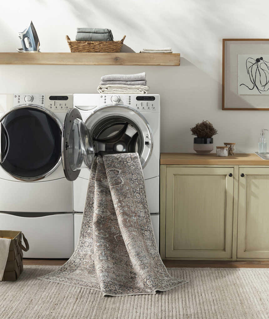 Laundry room scene with Jill Washable Area Rug emerging from the washing machine. Farmhouse style, brown, blue, vintage rug. Washing-Machine