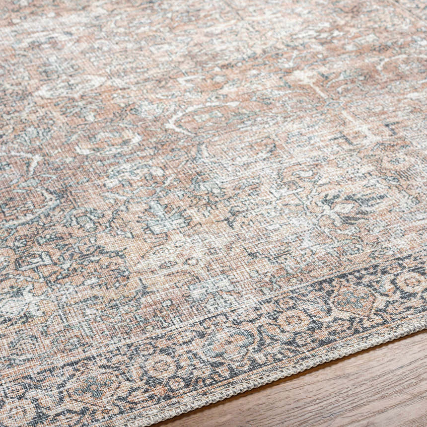 Close-up of the Jill Washable Area Rug. Features a vintage Persian design in brown, dark blue, and seafoam. Machine woven texture. Texture
