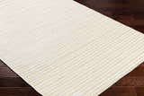 Close-up of Greg Beige Area Rug showing a striped pattern and woven texture on dark wood flooring. Corner