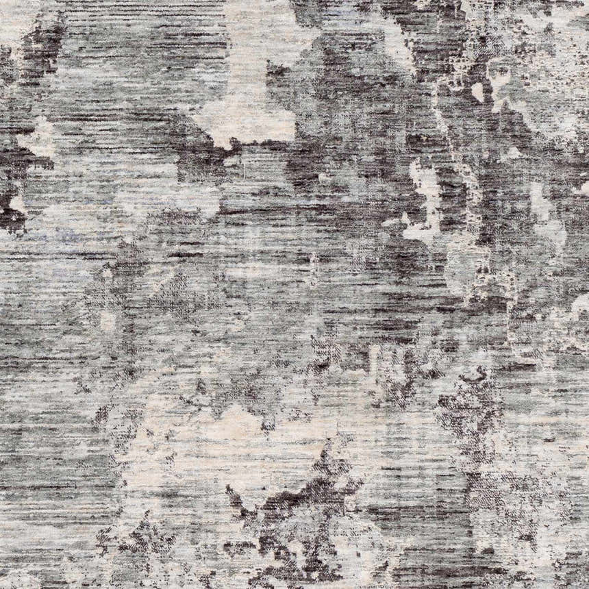 Close-up of the Johnetta Carved Statement Rug. Abstract pattern in shades of gray, charcoal, ice blue and ivory. Contemporary style. Swatch
