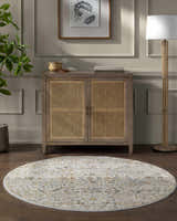 Entryway with a round Kabungahan Oushak Style Floral Rug, wood cabinet, lamp, and plant on a dark wood floor. Roomscene-Round