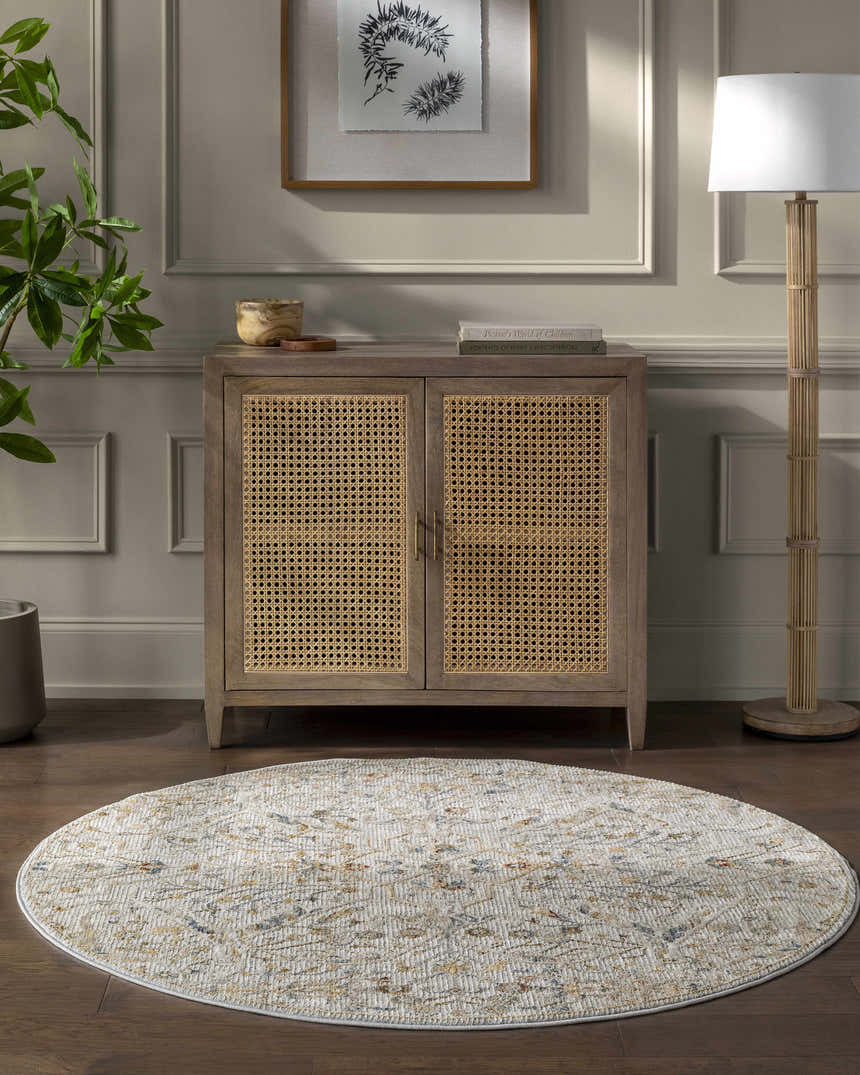Entryway with a round Kabungahan Oushak Style Floral Rug, wood cabinet, lamp, and plant on a dark wood floor. Roomscene-Round