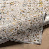 Close-up of the Kabungahan Oushak Style Floral Rug. Features a traditional floral pattern in brick red, cream, denim, and mustard. Fold