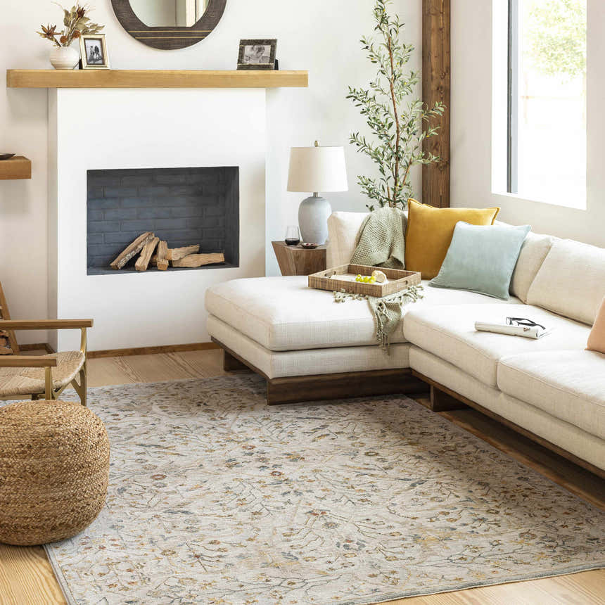 Living room scene with a cream sofa and the floral Kabungahan Oushak Style Rug in light brown, cream, and denim. Roomscene-Rectangle