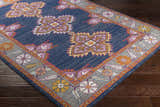 Close-up of Kaitlyn Navy Area Rug. Features a traditional floral and geometric design in navy, orange, and gray. Corner